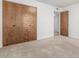 Cozy bedroom features plush carpeting and ample closet space with wood doors at 1704 E Hackamore St, Mesa, AZ 85203