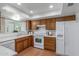 Bright kitchen with wooden cabinets, white appliances and countertops, and a window over the sink at 1704 E Hackamore St, Mesa, AZ 85203