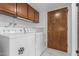 Functional laundry room includes washer, dryer, and overhead storage at 1704 E Hackamore St, Mesa, AZ 85203