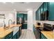 Bright kitchen features teal cabinets, stainless steel appliances, island and a farmhouse sink at 1736 E Joelle Dr, Casa Grande, AZ 85122