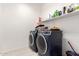 Neat laundry room with full-size washing machines, and an overhead shelf for storage at 1736 E Joelle Dr, Casa Grande, AZ 85122
