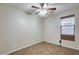 Cozy bedroom with neutral walls, ceiling fan, a window with shade, and tile flooring at 17789 W Bridger St, Surprise, AZ 85388