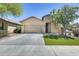 Attractive single-story home featuring a two-car garage, manicured lawn, and mature trees at 17789 W Bridger St, Surprise, AZ 85388