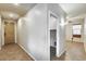 Hallway with tiled floors and neutral walls leads to various rooms at 17789 W Bridger St, Surprise, AZ 85388