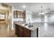 Kitchen island with double sink, dishwasher and tiled flooring at 17789 W Bridger St, Surprise, AZ 85388