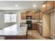 Well-lit kitchen featuring wood cabinetry, an island, and a view into the living room at 17789 W Bridger St, Surprise, AZ 85388
