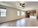Open-concept living space with tile floors, multiple windows for natural light, and a view of the kitchen at 17789 W Bridger St, Surprise, AZ 85388