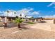 A landscaped backyard with gravel, palm trees, and a covered patio at 1852 N Grand St, Mesa, AZ 85201