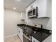 Modern kitchen featuring white cabinetry, stainless steel appliances, and black countertops at 1852 N Grand St, Mesa, AZ 85201