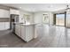 Bright, airy living space featuring tile floors, island, and a stainless steel dishwasher overlooking an additional sitting area at 2181 N 211Th Dr, Buckeye, AZ 85396