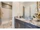 Stylish bathroom with granite countertops, a modern vanity, and a glass-enclosed shower at 23134 E Nightingale Rd, Queen Creek, AZ 85142