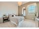This bedroom features neutral tones, a black framed mirror, and a window at 23134 E Nightingale Rd, Queen Creek, AZ 85142