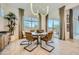 Elegant dining room with a modern chandelier, large window, and sliding glass doors to the patio at 23134 E Nightingale Rd, Queen Creek, AZ 85142