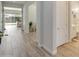 Bright hallway with wood-look tile, leading to an open living area and a bathroom at 24314 N 21St Pl, Phoenix, AZ 85024