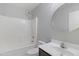 Bathroom features tub and shower combination and a large round mirror at 2625 E Beverly Rd, Phoenix, AZ 85042