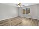 Bedroom with light gray walls, wood-look floors, ceiling fan and a window with blinds at 2625 E Beverly Rd, Phoenix, AZ 85042