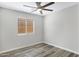 Bedroom with light gray walls, wood-look floors, ceiling fan and a window with blinds at 2625 E Beverly Rd, Phoenix, AZ 85042