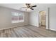 Bright bedroom with wood-look flooring, ceiling fan, and arched bathroom entrance at 2625 E Beverly Rd, Phoenix, AZ 85042