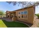 Well-maintained backyard features a covered patio, outdoor kitchen, and lush green lawn for outdoor enjoyment at 29159 N 128Th Ln, Peoria, AZ 85383
