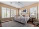 Well-lit bedroom with many windows featuring plantation shutters, ceiling fan, wood floor and stylish rug at 29159 N 128Th Ln, Peoria, AZ 85383