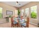 Bright dining room with a modern glass table and large windows overlooking the yard at 29159 N 128Th Ln, Peoria, AZ 85383
