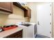 Functional laundry room features modern washer and dryer, storage cabinets, and access to the exterior at 29159 N 128Th Ln, Peoria, AZ 85383