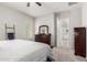 Neutral bedroom with a patterned bedspread, dark wood dresser and walk-in closet at 3081 E Desert Broom Pl, Chandler, AZ 85286