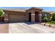 Exterior view of a single-story home with a two car garage, desert landscaping, and an arched front entryway at 3081 E Desert Broom Pl, Chandler, AZ 85286