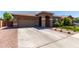 Exterior view of a single-story home with a two car garage, desert landscaping, and an arched front entryway at 3081 E Desert Broom Pl, Chandler, AZ 85286
