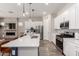 Open kitchen with a quartz countertop island, stainless steel appliances, and white cabinetry at 3081 E Desert Broom Pl, Chandler, AZ 85286