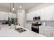 Bright kitchen with white cabinets, a stainless steel range, and a stylish patterned backsplash at 3081 E Desert Broom Pl, Chandler, AZ 85286
