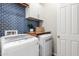 Modern laundry room with blue tile backsplash, built-in cabinets, and new appliances at 3081 E Desert Broom Pl, Chandler, AZ 85286