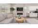 Bright living room showcasing a stone fireplace, a modern gray sofa, and a round coffee table at 3081 E Desert Broom Pl, Chandler, AZ 85286