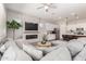 Spacious living room featuring a stone fireplace, modern ceiling fan, and a comfortable gray sectional sofa at 3081 E Desert Broom Pl, Chandler, AZ 85286