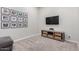 Comfortable carpeted den features a media console with baskets and a decorative gallery wall at 3081 E Desert Broom Pl, Chandler, AZ 85286
