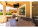 Outdoor kitchen with stainless steel grill, counter seating, and covered patio at 3081 E Desert Broom Pl, Chandler, AZ 85286