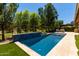 Beautiful pool featuring a travertine surround, tile accents, and a well-maintained yard with mature trees at 3081 E Desert Broom Pl, Chandler, AZ 85286