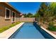 Tranquil backyard pool with travertine surround and lush landscaping, perfect for relaxing and enjoying the outdoors at 3081 E Desert Broom Pl, Chandler, AZ 85286
