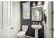 Stylish powder room with a pedestal sink, dark accent wall, and modern lighting fixtures at 3081 E Desert Broom Pl, Chandler, AZ 85286