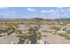 Expansive aerial view of a desert neighborhood with tile roof homes, lush landscaping, and golf course with mountain backdrop at 33575 N Dove Lakes Dr # 2033, Cave Creek, AZ 85331