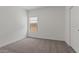 Clean, carpeted bedroom with a window and a white door at 3913 S 233Rd Ln, Buckeye, AZ 85326