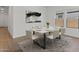Bright dining room with large windows and modern furnishings, with a decorative rug at 3913 S 233Rd Ln, Buckeye, AZ 85326
