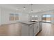 Open concept kitchen with an island, white cabinetry, and hardwood floors at 3913 S 233Rd Ln, Buckeye, AZ 85326