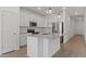 Bright kitchen with white cabinets, an island, and stainless steel appliances at 3913 S 233Rd Ln, Buckeye, AZ 85326
