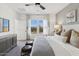 Bright main bedroom with neutral tones, two stools, a ceiling fan, and a beautiful view of outdoors at 3913 S 233Rd Ln, Buckeye, AZ 85326