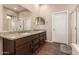 A spacious bathroom featuring a double sink vanity with granite countertops and wood floors at 41638 N Emerald Lake Dr, Anthem, AZ 85086
