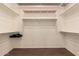 A large walk-in closet featuring built in shelving with brown floors and white walls at 41638 N Emerald Lake Dr, Anthem, AZ 85086