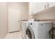 Bright laundry room with a washer, dryer, white cabinets, and neutral-colored walls at 41638 N Emerald Lake Dr, Anthem, AZ 85086