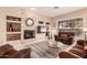 Cozy living room featuring a stone fireplace, comfortable seating, and a large window at 41638 N Emerald Lake Dr, Anthem, AZ 85086