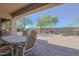 Covered patio with a dining table and chairs overlooking the landscaped backyard at 41638 N Emerald Lake Dr, Anthem, AZ 85086
